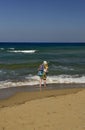 A woman wetting her bare feet on a Mediterranean Cypriot beach.