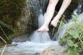 Woman wetting her feet in a stream.