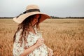 Woman wheat field nature. Happy young woman in sun hat in summer wheat field at sunset. Copy space, sunset, flare light