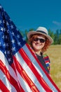 Woman in a wheat field with a USA flag