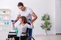 Woman in wheel-chair doing sport exercises with personal coach Royalty Free Stock Photo