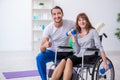 Woman in wheel-chair doing sport exercises with personal coach Royalty Free Stock Photo