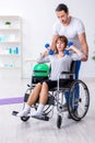 Woman in wheel-chair doing sport exercises with personal coach Royalty Free Stock Photo