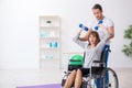 Woman in wheel-chair doing sport exercises with personal coach Royalty Free Stock Photo