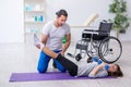 Woman in wheel-chair doing sport exercises with personal coach Royalty Free Stock Photo