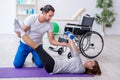 Woman in wheel-chair doing sport exercises with personal coach Royalty Free Stock Photo