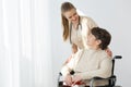 Woman on wheelchair and caregiver smiling