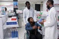 Woman in wheelchair choosing prescription treatment in drugstore Royalty Free Stock Photo