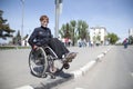 Woman in a wheelchair crosses the road