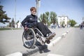 Woman in a wheelchair crosses the road