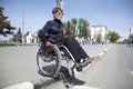 Woman in a wheelchair crosses the road