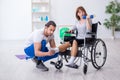 Woman in wheel-chair doing sport exercises with personal coach Royalty Free Stock Photo