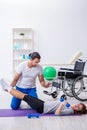 Woman in wheel-chair doing sport exercises with personal coach Royalty Free Stock Photo