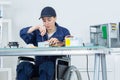 Woman in wheelchair fixing computer Royalty Free Stock Photo