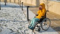 Woman in wheelchair getting cold in winter park. Royalty Free Stock Photo