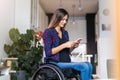 Woman In Wheelchair on Smartphone At Home Royalty Free Stock Photo