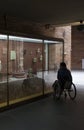 Woman in a wheelchair iobserves glass cabinet Royalty Free Stock Photo