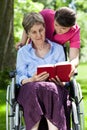 Woman on wheelchair reading book Royalty Free Stock Photo