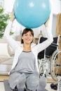 woman in wheelchair rehabilitating with ball at home