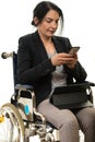 Woman in wheelchair sending message by phone Royalty Free Stock Photo