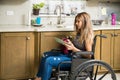 Woman in wheelchair washing dishes