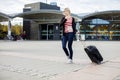 Woman With Wheeled Luggage Walking Outside Train Station