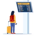 Woman with wheeled suitcase and backpack looks at the departures board at airport. Passenger in airport waiting room or departure Royalty Free Stock Photo