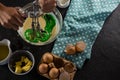 Woman whisking batter after adding green food color