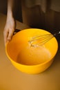 A woman whisking dough in a mixing bowl at home in her kitchen, preparing a homemade bakery delight for breakfast