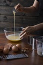 A woman whisking eggs and spices in a bowl at kitchen