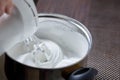 Woman whisking with mixer eggs whites with sugar