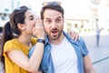 Woman is whispering a secret into his boyfriends ear Royalty Free Stock Photo