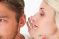 Woman whispering secret into a mans ear