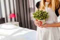 Woman in white apron holding house plant