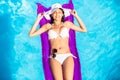 Woman in white bikini lying on air bed in pool Royalty Free Stock Photo