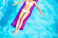 Woman in white bikini lying on air bed in pool Royalty Free Stock Photo