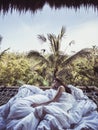 Woman in white blanket on hammock in tree house. Naked woman in morning wakeup. Royalty Free Stock Photo