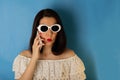 Woman in a white blouse and sunglasses with red lipstick and nail polish talking on a smartphone. Royalty Free Stock Photo