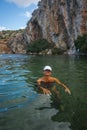 Woman in a white cap covered with fish peeling at the Voulagmeni thermal lake, Greece