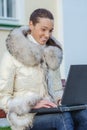 Woman in white coat sitting on bench Royalty Free Stock Photo