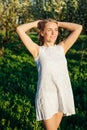 woman in white dress in a blossoming garden in a park in nature journey walk