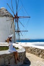 Woman in white dress in front of windmills in Mykonos Royalty Free Stock Photo