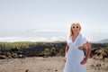 A woman in a white dress and glasses on the slope of the Teide volcano. Desert landscape in Tenerife. Teide National Royalty Free Stock Photo