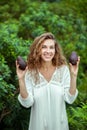 Woman in white dress holding avocado in hands