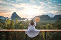 Woman with the white dress sit and see the mountain in early morning at Samet Nangshe viewpoint in Andaman sea on morning cloudy Royalty Free Stock Photo