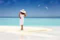 Woman in a white dress stands on a tropical beach Royalty Free Stock Photo