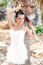 Woman in white dress on tropical beach near palm trees. Royalty Free Stock Photo