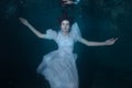 Woman in a white dress under water.