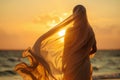 A woman in a white dress is walking on the beach at sunset Royalty Free Stock Photo