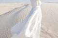 Woman in white dress on white sand dunes